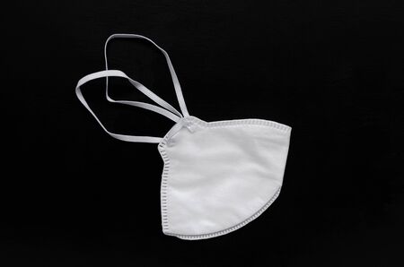 Coronavirus concept. white medical mask on black slate background. Epidemic of coronavirus infection. Pandemic. copy space or image placementの写真素材