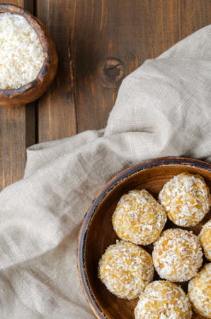 nutrition for athletes healthy snack. homemade healthy energy balls made from natural ingredients of dried oatmeal honey dried fruit nuts in coconut flakes without sugar on a ceramic plate ingredientsの写真素材