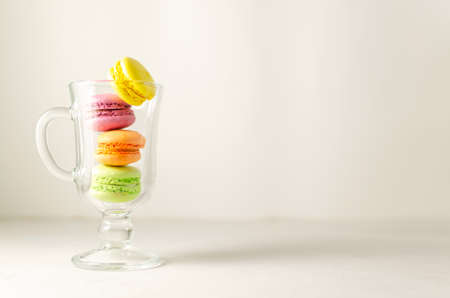 Delicious sweet cookies, colored cakes with macaroons in a transparent glass cup. White background. summer cocktail concept. close-up with copy spaceの写真素材