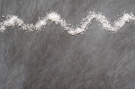 wave from coarse sea salt, on gray concrete background, top view with place for textの写真素材