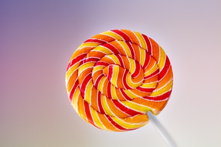 yellow-red lollipop on a multi-colored backgroundの写真素材