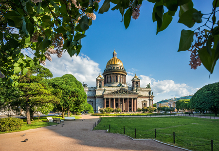St. Isaac's Cathedral under the blue sky and lilacs in the park in St. Petersburg on a summer sunny morningのeditorial素材