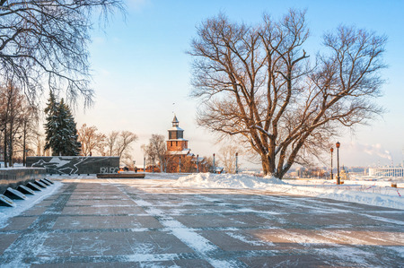 Clock tower of the Nizhny Novgorod Kremlin and a monument to the fallen soldiers in the Patriotic War with eternal fire in the winter sunny dayの写真素材