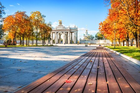 Maple red leaf on a bench near the main entrance of VDNH in Moscow on an autumn sunny dayの写真素材