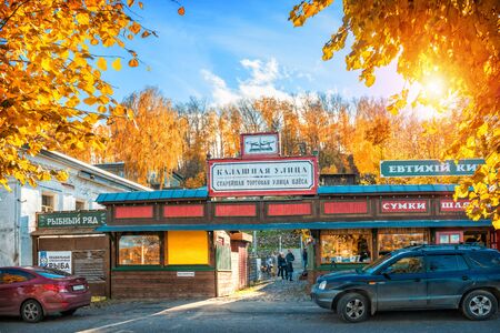 Buildings of Shopping Rows on the market in Plyos and red autumn trees on a sunny dayの写真素材