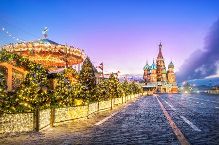 New Year's carousel on Red Square and St. Basil's Cathedral on a pink winter morningの写真素材