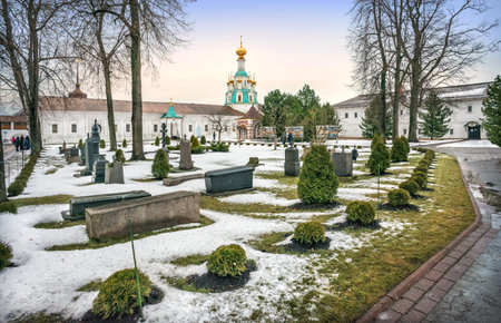Spasskaya church and gravestones of the Tolgsky monastery in Yaroslavl under a blue-yellow sky on a...
