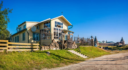 The wooden building of the Shelter Hotel on the Solovetsky Islands opposite the Solovetsky Monastery in the rays of the autumn sun