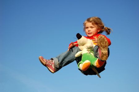 Flying pretty girl, holding toy in handsの写真素材