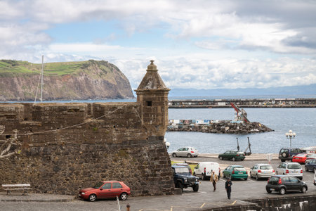 HORTA, PORTUGAL - MAY 04, 2012: Walls of the fortress Forte de Santa Cruz with a turret against background of port. Faial Island, Azoresのeditorial素材
