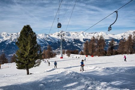 VEYSONNAZ, SWITZERLAND - FEBRUARY 04, 2010: Skiers adults and children climb up on the rope tow and go down on a simple gentle slope for beginners along the ropewayのeditorial素材