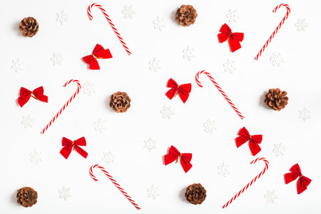 Simple christmas background of snowflakes, candy canes, bows and pine cones on a white backgroundの写真素材