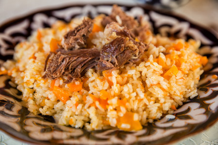 Uzbek pilaf, a traditional dish of Central Asian cuisine, on a plate with oriental patternの写真素材