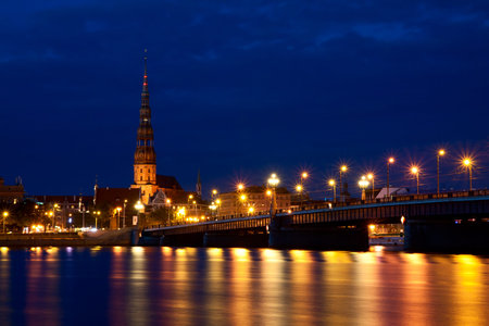 St. Peter's Church and bridge across Daugava river in Riga at night
