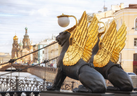 Winged griffins on the Bank bridge over the Griboyedov canal and the Cathedral of the Savior on Spilled Blood, St. Petersburg, Russiaの写真素材