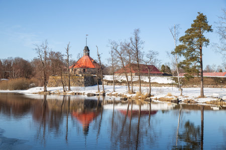 Ancient fortress of Korela is reflected in the water of the Vuoksa River. Early spring natural landscape. Priozersk, Leningrad region, Russiaの写真素材