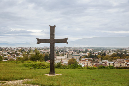 Cross near Bagrati Cathedral on the background of the cityscape of Kutaisi, Georgia