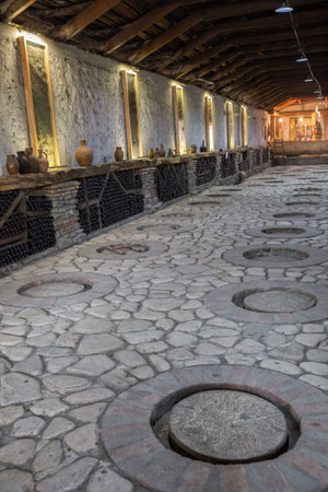 KVARELI, GEORGIA - OCTOBER 01, 2018: Making wine at traditional Georgian technology in large clay...