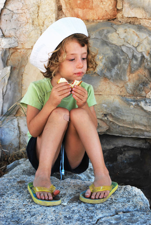 Adorable girl eating sandwich in natureの写真素材
