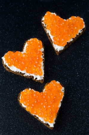 three sandwich with red caviar in the form of a heart の写真素材