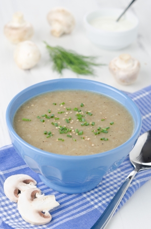 mushroom soup with cheese and herbs in a blue bowlの写真素材