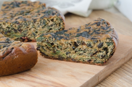 piece of cake with greens on a wooden cutting boardの写真素材