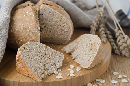 Bread with oat flakes chopped to pieces on a wooden board