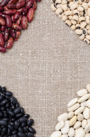 Frame of the different kinds of beans on burlap backgroundの写真素材
