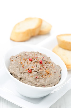 liver pate with pink pepper in a white bowl, vertical close-upの写真素材
