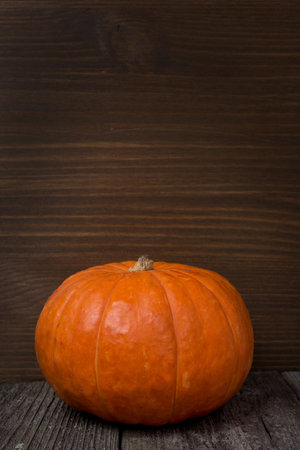 Orange pumpkin on the old wooden background and space for text, verticalの写真素材