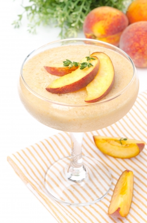 peach souffle in glass and fruit in the background, isolated on a white backgroundの写真素材