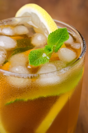 glass of ice tea with lemon and mint on a wooden background close-up, selective focusの写真素材