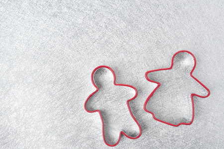two baking dish in the form of little men on a silver background, top view
