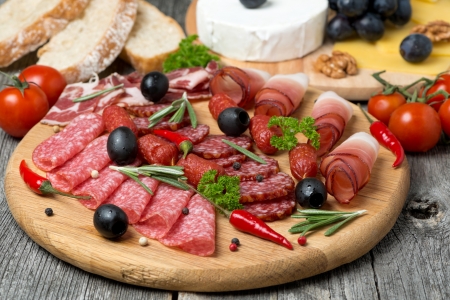 Assorted meats and sausages on a wooden board, horizontalの写真素材