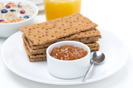 breakfast - crisp bread with jam, orange juice and muesli, close-up