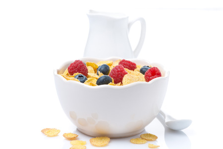 cornflakes with berries and jug of milkの写真素材