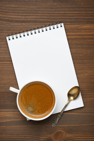 cup of coffee, spoon and note pad, concept photo, verticalの写真素材
