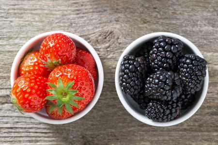 strawberries and blackberries in bowls, top view, close-upの写真素材