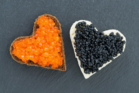 toast with red and black caviar in the form of heart on a dark background, close-up, top viewの写真素材
