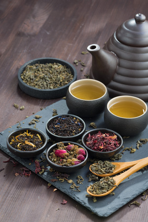 assortment of fragrant dried teas and green tea on wooden table, verticalの写真素材