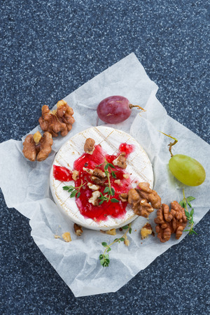 Camembert with berry jam, grapes and nuts, vertical, top view, close-upの写真素材