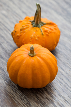 Decorative pumpkins on wooden background, top view, verticalの写真素材