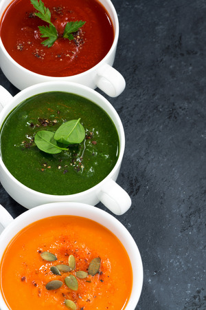 assortment of fresh vegetable soup on a black background, vertical, closeupの写真素材