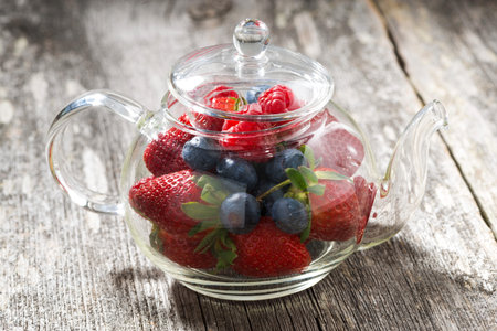 glass teapot with fresh berries, closeupの写真素材