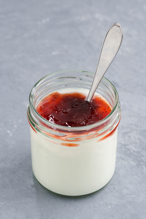 jar of natural yoghurt with fruit jam, verticalの写真素材