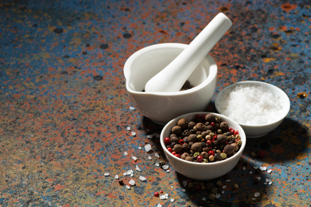 assortment of pepper, sea salt and a mortar on a dark background, horizontalの写真素材