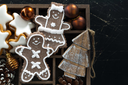 Christmas symbols in a wooden box on black wooden background, closeup