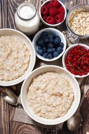homemade oatmeal and berries on table, top view, verticalの写真素材
