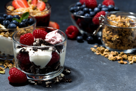 various desserts with fresh berries and cream on dark background, closeup, horizontalの写真素材