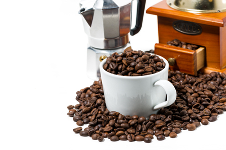 cup with coffee beans and handmilled coffee grinder on white background, closeupの写真素材